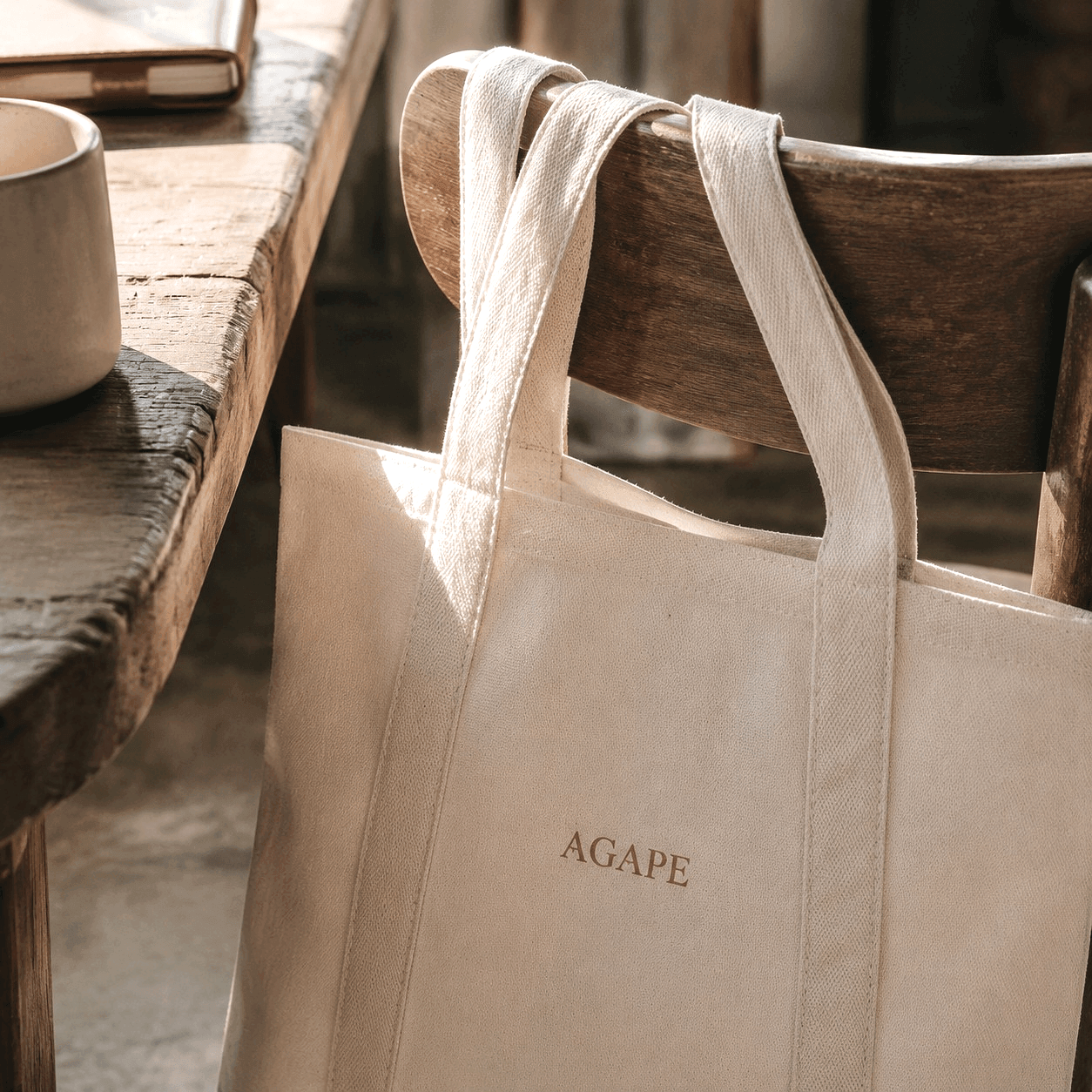 Agape canvas tote detail beside a wood table